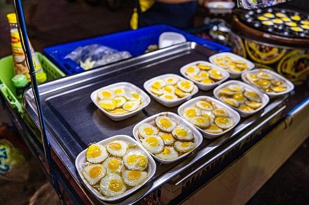 传统的泰国街快食物鹌鹑鸡蛋煮熟的加热地幔热缩进煎锅亚洲厨房美味文化烹饪零食食物