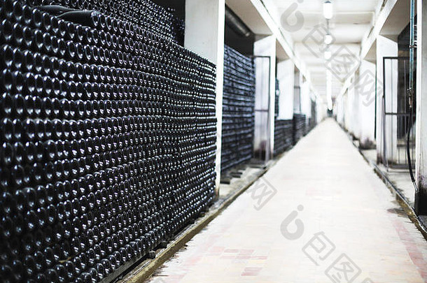 葡萄园酒窖货架上一排酒瓶的透视图