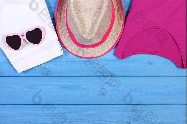 蓝色板、太阳镜、草帽、衬衫、裤子上的女士服装和度假和夏季配饰，