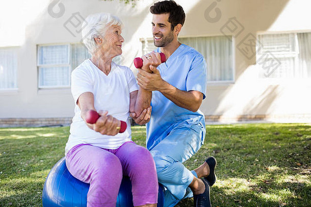 护士帮助老年妇女做运动