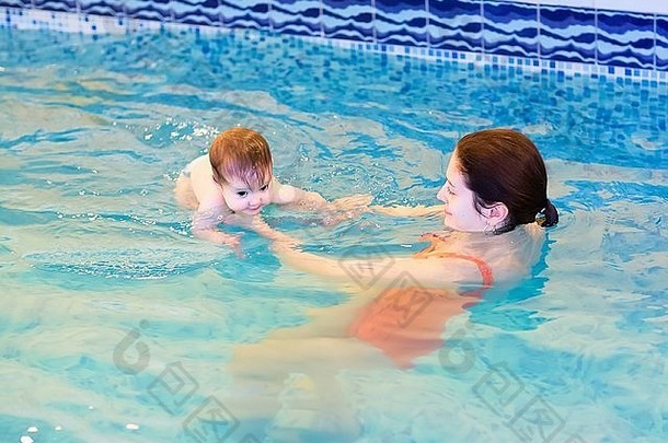 蓝眼睛的小婴儿正在学习游泳