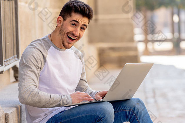 穿着休闲服的年轻迷人的新潮男子在欧洲的一家商店里学习使用笔记本电脑上网、写博客、聊天和查看电子邮件