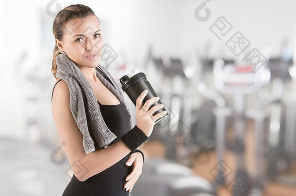 健身锻炼后，在健身房用毛巾围住脖子休息的女人