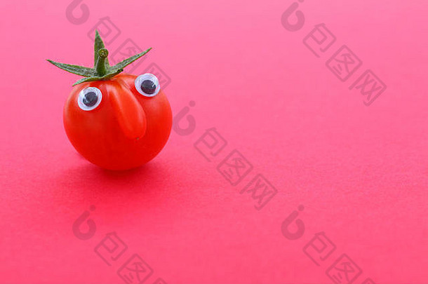 新鲜成熟的樱桃番茄，有一张脸，背景朴素，留有空间
