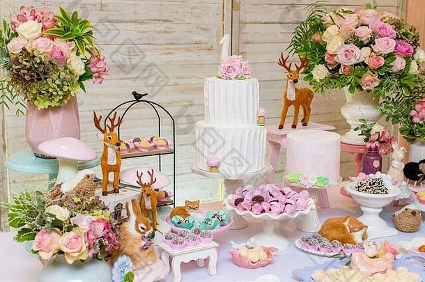豪华的表格糖果生日蛋糕装饰花安排精致的野生动物光木面板背景情郎