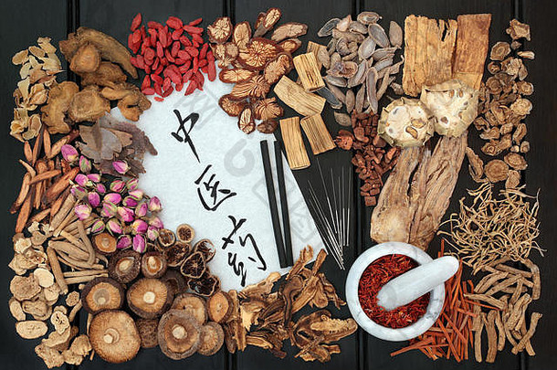 用于针灸治疗的中国针灸针和艾条，在深色木材背景上使用传统草药。