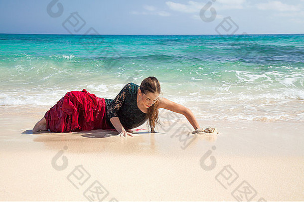 海边穿着红绿相间的弗拉门戈连衣裙的年轻迷人的女人
