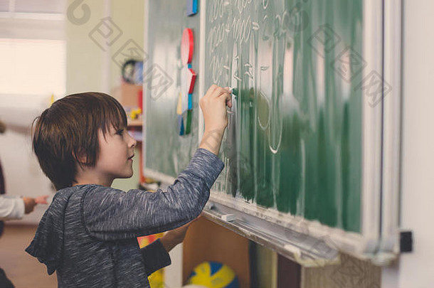 <strong>一年级</strong>的孩子，在学校学习数学，形状和颜色，站在黑板前