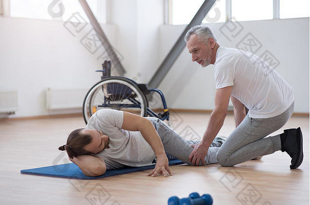 考虑到物理治疗师伸展运动禁用男人。健身房