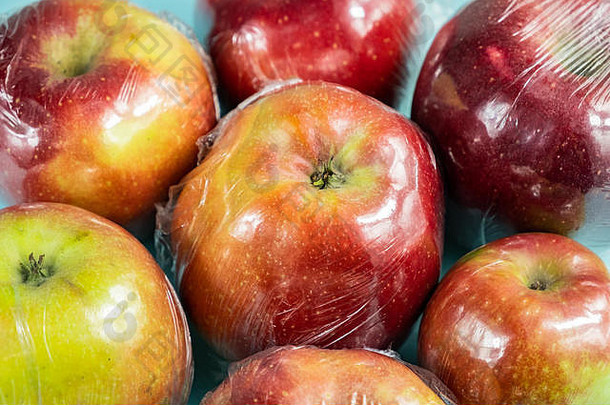 过度使用塑料的概念：新鲜的苹果在厨房包装。不合理过度包装的食品：保鲜膜中的新鲜水果，特写镜头
