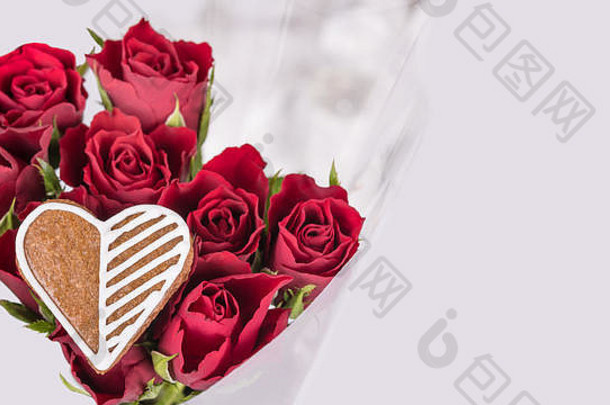 一束红玫瑰和甜心，祝你好运。花朵情人节背景，装饰华丽的姜饼。母亲节或妇女节、生日、婚礼。