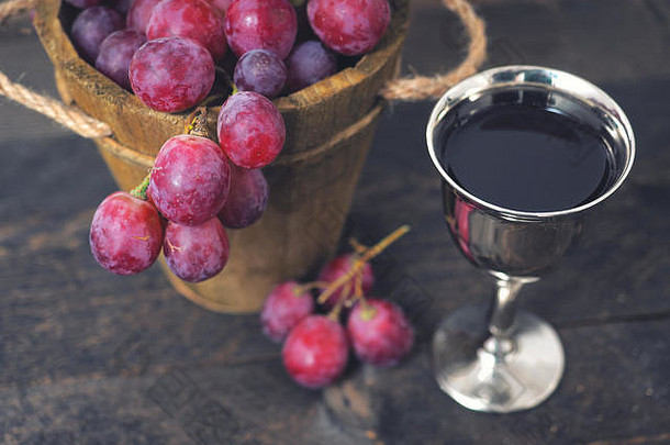 红酒和葡萄。葡萄酒和葡萄陈酿，木塞放在木桌上