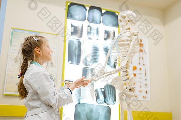 穿制服的女孩用人体骨骼扮演医生