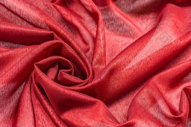 褶皱红色弯曲布料材料碎片，以漩涡为织物背景纹理