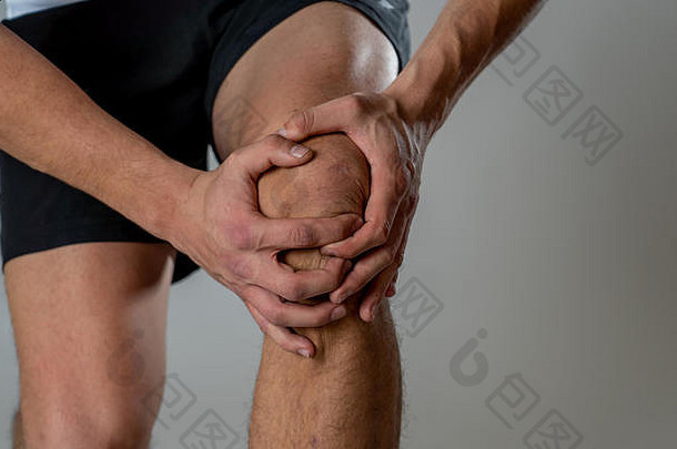 年轻的适合男人。持有膝盖手疼痛痛苦肌肉受伤破碎的骨腿疼痛扭伤抽筋运行锻炼身体疼痛