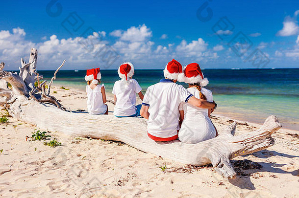 回来视图美丽的家庭穿红色的圣诞老人帽子热带海滩庆祝圣诞节