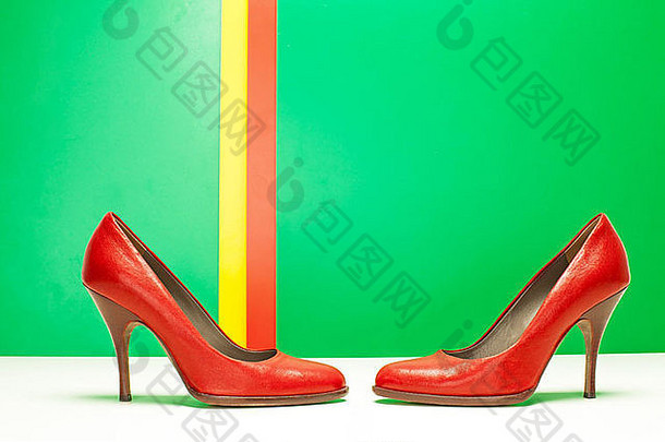 一对红色的高高跟鞋绿色条纹背景