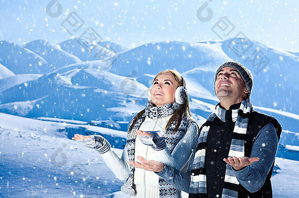 快乐的一对在冬季山脉户外玩耍，活跃的人们在自然蓝色的冬季景观背景上玩耍