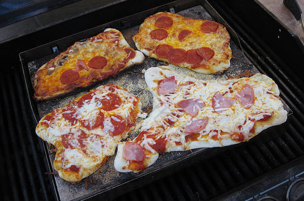 一张在烧烤炉上手工制作的比萨饼的特写镜头。
