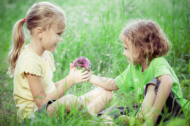 白天，两个快乐的孩子在树旁玩耍。概念兄弟姐妹永远在一起