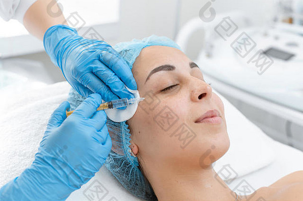 美容师使专业复兴维生素注射皮肤病人的脸年轻的女孩经历水疗中心治疗