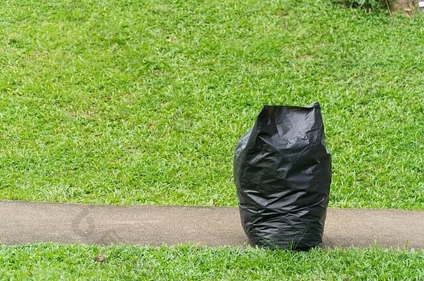 黑色的垃圾袋绿色草公园