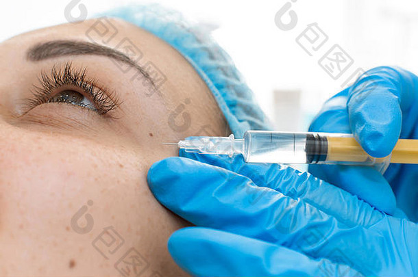 美容师为患者面部皮肤注射专业的回春维生素。一个年轻女孩正在接受一个疗程的水疗