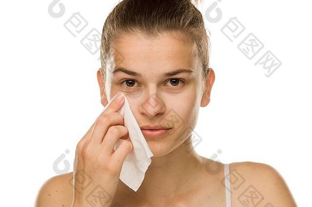 年轻女子在白色背景上用湿巾擦脸