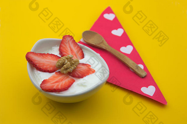 健康的早餐酸奶滚草莓木勺子餐巾白色心红色的