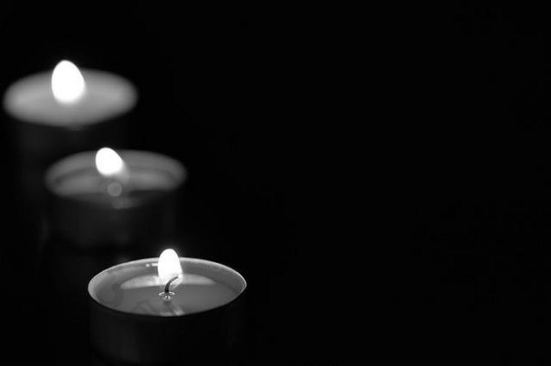 一些在黑暗中燃烧的蜡烛，黑色和白色