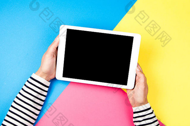女人的手与彩色背景上的平板电脑。
