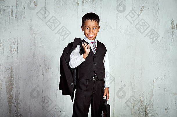 第一个上学日，身穿校服，背着背包和玫瑰花束的<strong>一年级</strong>黑人男孩面带微笑