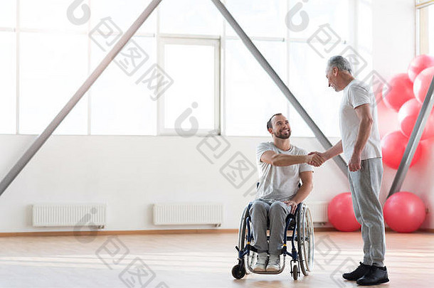 积极的物理治疗师在健身房会见残疾患者