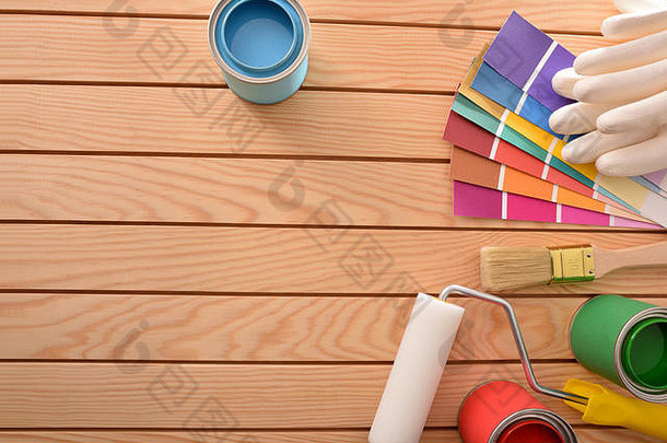 五颜六色的油漆罐打开，工具放在木桌上，用于装修材料和做家务。家庭diy概念。顶视图。水平构图。