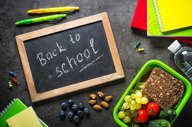 回来学校概念学校办公室文具背包午餐盒子黑色的背景前视图