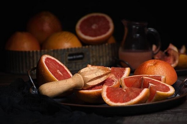 新鲜葡萄柚片，用于在盘子上制作<strong>鲜榨果汁</strong>，深色背景
