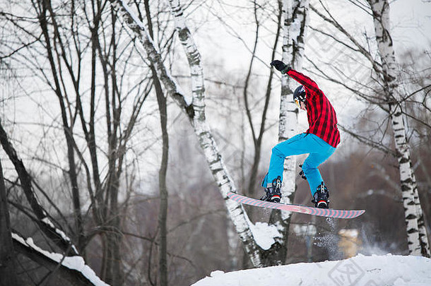 戴头盔的运动员在雪坡上滑雪板的图像