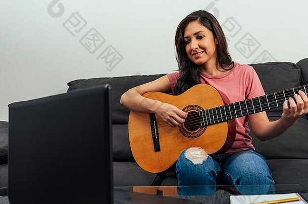 女人坐着沙发首页采取吉他教训在线在线学习概念