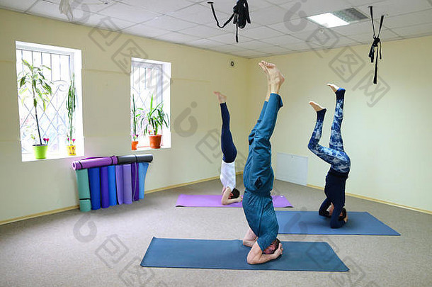 年轻的女瑜伽教练教男孩和女孩做练习