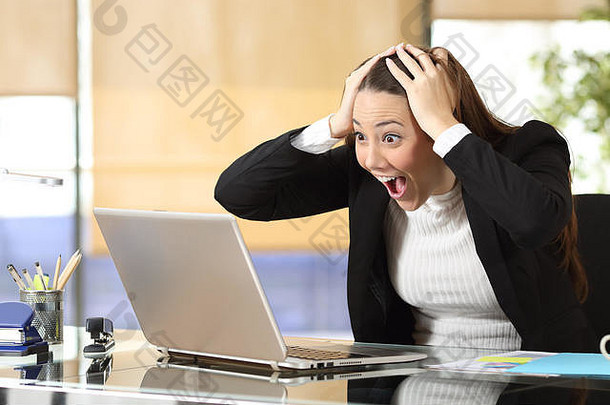 兴奋的女商人在办公室查看笔记本电脑在线内容阅读在线好消息