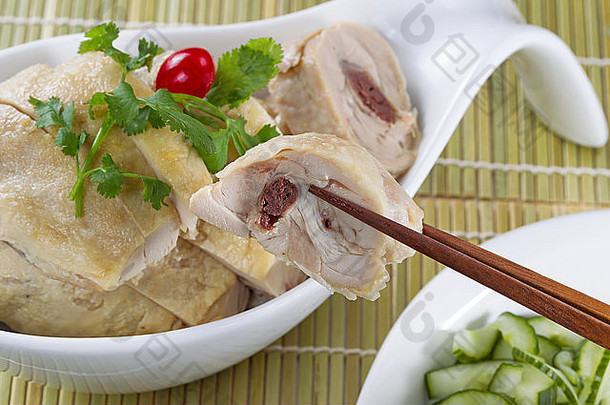 中国烤鸡片，用筷子夹一片，装在白碗里，配黄瓜片