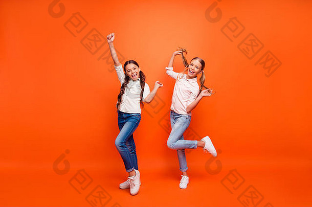 时髦疯狂的两个女朋友在秋季周末玩得很开心的全身照片举手拳头握臂辫子穿白衬衫运动鞋