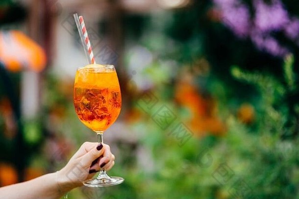 新鲜的鸡尾酒酒玻璃户外模糊背景女人持有夏天冷喝冰水平拍摄美味的acoholic饮料