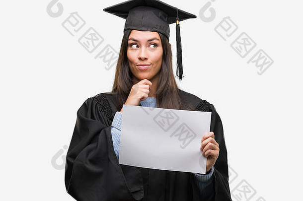 年轻的西班牙裔女子穿着毕业制服，手里拿着毕业证书纸严肃地面对问题思考，很困惑的想法