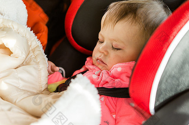 可爱的婴儿女孩睡觉车座位旅行车