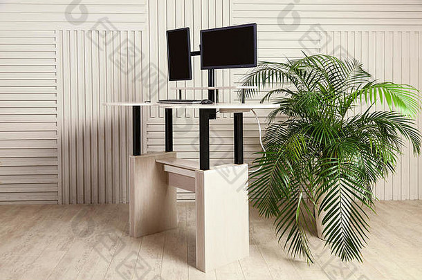 一张带有两个操纵器的办公桌，一个用于操纵器支架的升降机构和一个可站立和坐着工作的桌面。A.