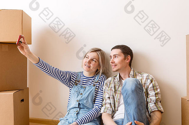 <strong>照片</strong>年轻的结婚了夫妇自拍坐着地板上纸板盒子