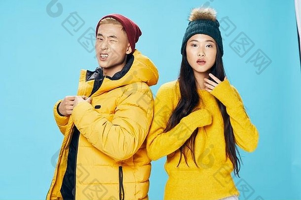 一个穿着黄色毛衣的漂亮女人和一个穿着保暖夹克的男人