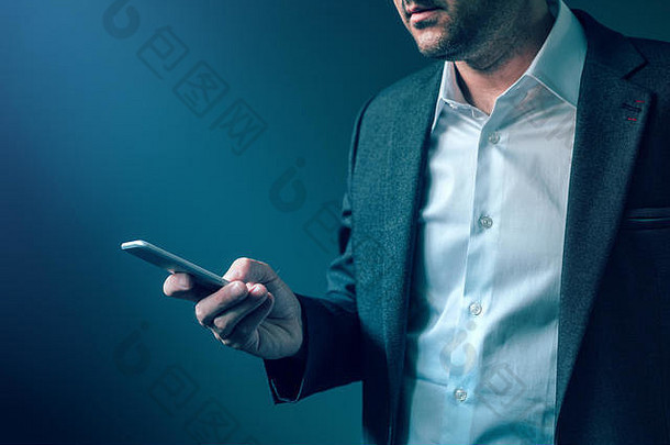 穿着优雅西装的男士看着手机屏幕，阅读<strong>推送通知</strong>、电子邮件或短信、现代通信和信息