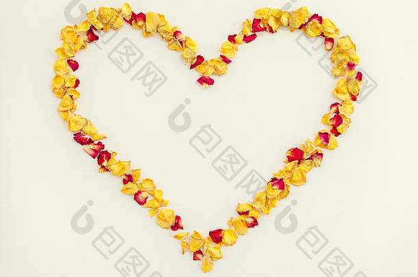 心形框架由黄色和红色的玫瑰<strong>花瓣</strong>制成，背景为淡粉色。